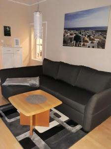 a living room with a black couch and a table at Ferienwohnung FLAIR in Zella-Mehlis