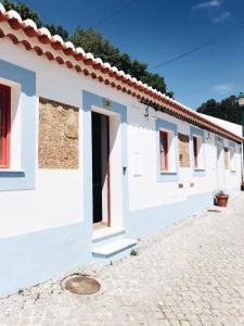 una fila de edificios blancos con ventanas rojas en Calma Aljezur, en Aljezur