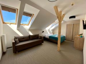 a attic bedroom with a bed and a couch at Promes Mielno in Mielno