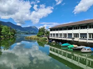 une rivière en face d'un bâtiment avec des bateaux dans l'eau dans l'établissement Helvetia, à Seewen