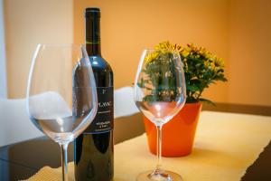 una bottiglia di vino e due bicchieri su un tavolo di Guesthouse Halilagic a Krk