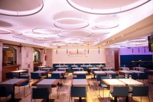 una sala da pranzo con tavoli e sedie e un cartello sul soffitto di Hotel Centro Los Braseros a Burgos
