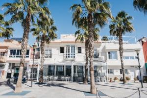 a building with palm trees in front of it at MalagadeVacaciones - El Pedregal in M&aacute;laga