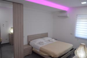 um quarto com uma cama com uma luz rosa em Quiero Más B&B em San Nicola Arcella