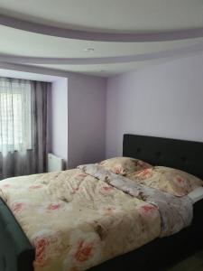 a bedroom with a bed with a floral comforter at Cintra in Middelkerke