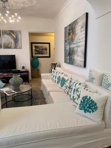 a living room with a white couch with pillows at Hotel Orsa Maggiore in Anacapri