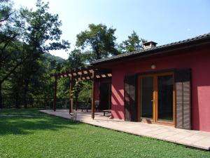 una casa roja con porche y patio de césped en Boyana Vacation Houses, en Cherni Vit