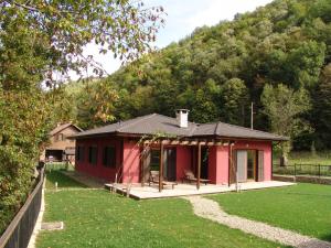 a red cabin in the middle of a yard at Boyana Vacation Houses in Cherni Vit