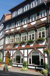 um edifício a preto e branco com janelas e plantas em Fachwerk-Kultur-Pension TangoBrücke em Einbeck