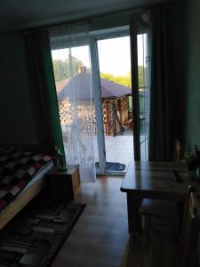 a room with a bed and a table and a sliding glass door at Przystań Laworta in Ustrzyki Dolne