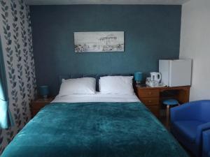 sypialnia z łóżkiem i niebieskim krzesłem w obiekcie The Chequers w mieście Great Yarmouth