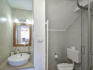 a bathroom with a sink and a toilet and a mirror at Studios Barre with Jacuzzi in Rovinj