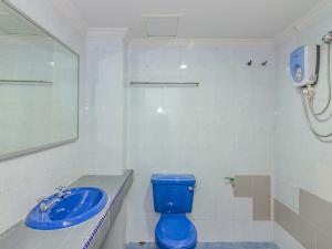 y baño con aseo azul y lavamanos. en Super OYO 1159 Hotel New Sabah, en Kota Kinabalu