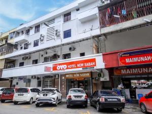 un grupo de coches estacionados frente a un edificio en Super OYO 1159 Hotel New Sabah, en Kota Kinabalu