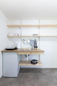 a kitchen with wooden shelves and a sink at Hotel Rusava chaty in Rusava