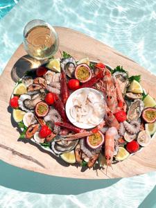 a plate of seafood on a board next to the water at Bellavista Suites in Monopoli