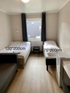 um pequeno quarto com 2 camas e uma janela em Mosjøen Overnatting, Finnskoggata 20 em Mosjøen