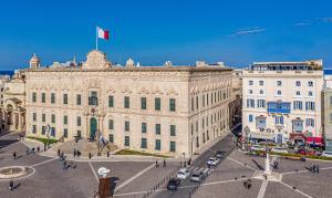 um grande edifício com uma bandeira em cima em Hotel Castille em Valletta