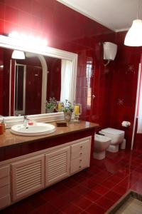 bagno rosso con lavandino e servizi igienici di Belvedere Sasso a Sasso