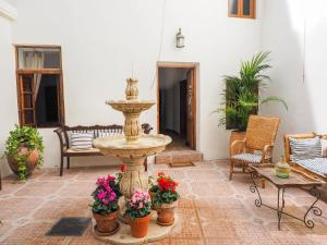 a fountain in the middle of a patio with flowers at La Casa de la Abuela in Villarta de San Juan