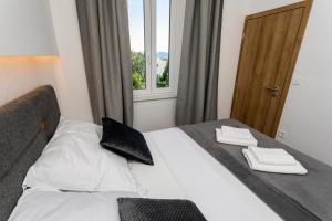 Una cama en una habitación de hotel con dos toallas. en Apartments San Leopoldo, en Crikvenica 119 fotos más