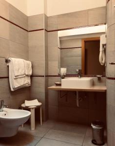 bagno con lavandino, servizi igienici e specchio di Hotel Capitol a San Mauro a Mare