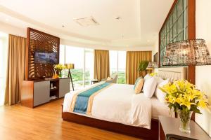a bedroom with a large bed and some windows at Ninh Kieu Riverside Hotel in Can Tho