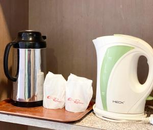 a counter with a tea kettle and some sugar packets at Hotel Rainbow in Cameron Highlands