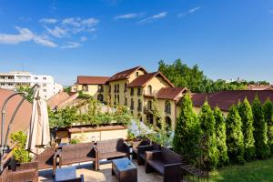 特爾古穆列什的住宿－派森膳食公寓，享有带长椅和遮阳伞的花园美景。
