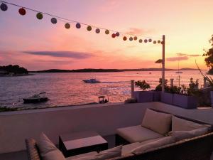 un patio con sofá y vistas al agua en Seafront rooms en Hvar