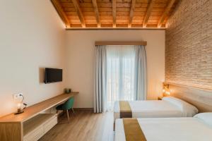 a hotel room with two beds and a desk and a window at HOTEL RESTAURANTE CASA LUISA in Estella