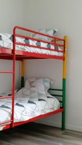 a red bunk bed with a white and green pillow at Le coryphée : Appartement en centre ville à Abbeville in Abbeville