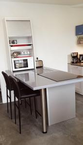 a kitchen with a table with chairs and a microwave at Le coryphée : Appartement en centre ville à Abbeville in Abbeville