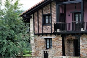 Una casa de ladrillo con un balcón en el lateral. en Bagadi, en Arantza
