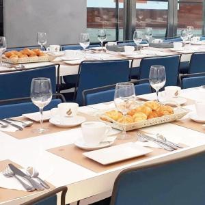 - une table avec des assiettes de pain et des verres à vin dans l'établissement Hotel Centro Los Braseros, à Burgos