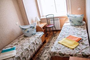 アフトゥビンスクにあるHotel Almazのベッド2台と窓が備わる小さな客室です。