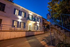 un edificio en una calle con un cartel delante en Apartments San Leopoldo, en Crikvenica