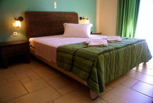 1 dormitorio con 1 cama con 2 toallas en Xenonas Afroditi, en Loutra