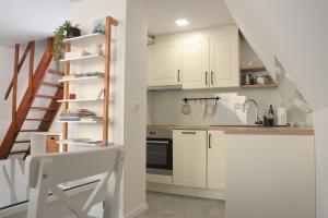 a kitchen with white cabinets and a staircase at Our Forest House in Tržič