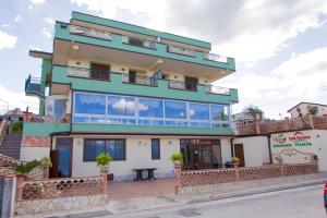 a large building with balconies on a street at Appartamenti Anzà in Capo dʼOrlando