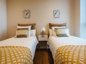 two beds sitting next to each other in a room at Magno Apartments San Martín Terrace in Seville