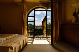 - une chambre avec une porte ouverte sur un balcon dans l'établissement Pension Passion, à Târgu-Mureş