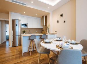 a kitchen and dining room with a white table and chairs at Magno Apartments San Martín Terrace in Seville