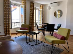 a living room with chairs and a table and windows at LE BAIN DE SOLEIL luxury 2 bedrooms Cannes centre in Cannes