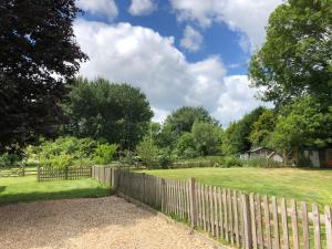 a wooden fence in a yard with a field at The Old Mill Bed and Breakfast in Bere Regis