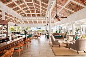 a lobby of a resort with a bar and chairs at Heritage Le Telfair Golf & Wellness Resort in Bel Ombre
