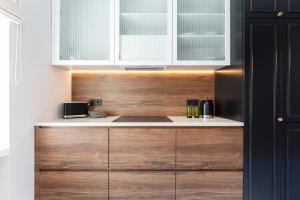a kitchen with white cabinets and a counter top at Apartament Premium na Rynku by Renters Prestige in Darłowo