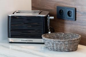 a toaster oven sitting on a counter next to a basket at Retro Apartament Premium na Rynku by Renters Prestige in Darłowo