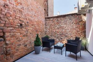 d'une terrasse avec des chaises et un mur en briques. dans l'établissement Apartament Premium na Rynku by Renters Prestige, à Darłowo