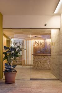 eine Lobby mit einer Topfpflanze vor einem Geschäft in der Unterkunft Hostal Residencia Nicolau in Sant Antoni de Portmany